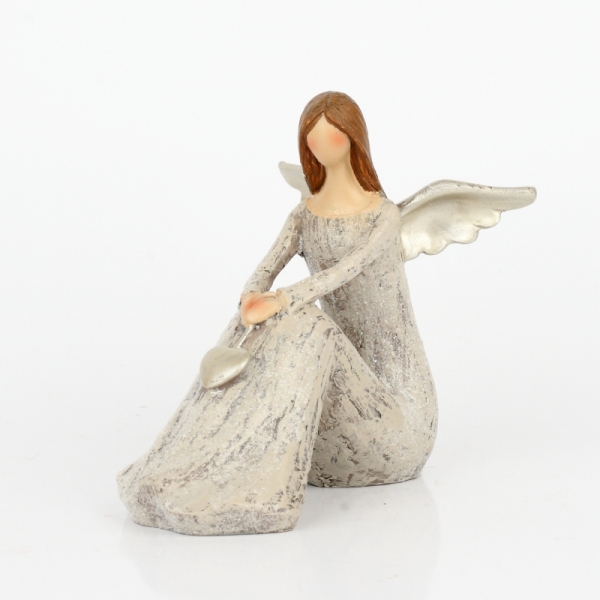 Anjel sediaci so zlatými krídlami a srdcom