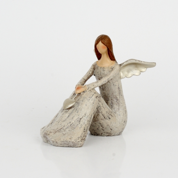 Anjel sediaci so zlatými krídlami a srdcom