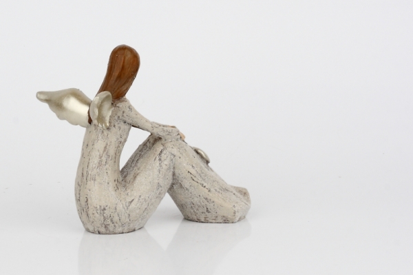 Anjel sediaci so zlatými krídlami a srdcom